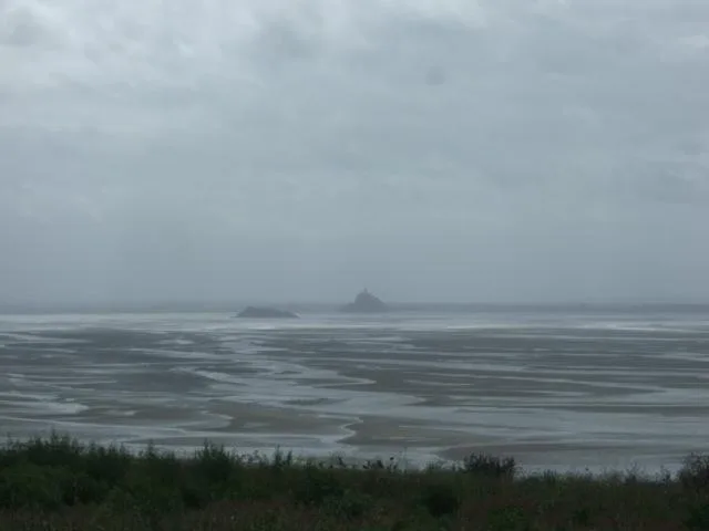 Le Mont Saint-Michel vu à travers la baie de marée dans la brume