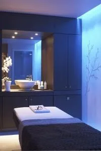 Table de massage dans une salle de soins tamisée à la Villa Thalgo