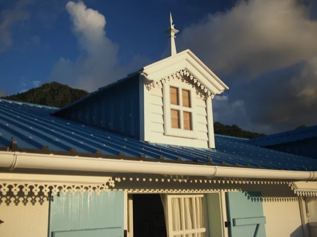 maison papaye Volets bleus et boiseries décoratives sur une maison d'hôtes mauricienne