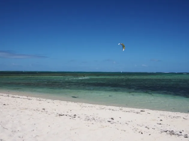 Plage de sable blanc et lagon du Morne avec une aile de kitesurf