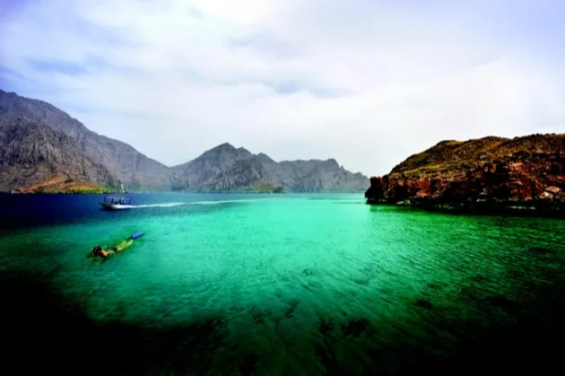 Lagon turquoise entouré de falaises sur la côte d’Oman