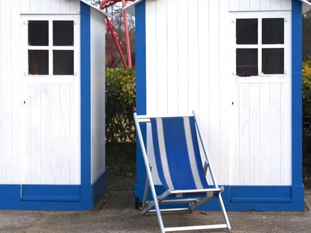 Deux cabines blanches et bleues avec une chaise longue