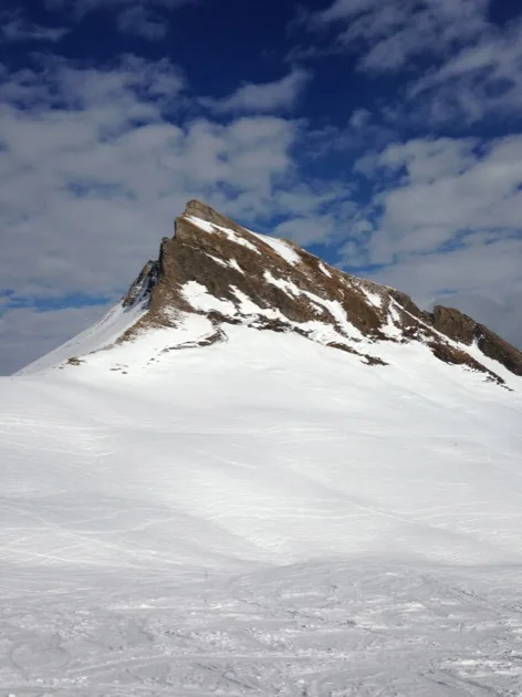 Pic Mittagspitze s'élevant au-dessus d'une pente enneigée à Damüls