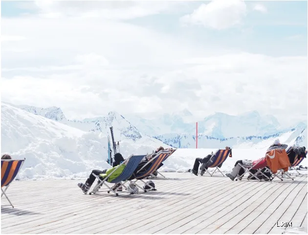Transats sur une terrasse de montagne ensoleillée avec vue sur les sommets enneigés