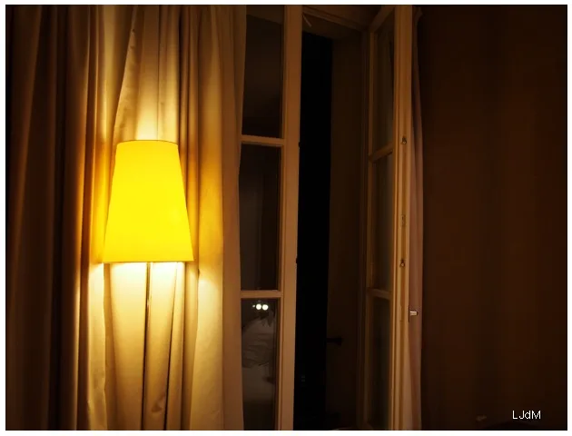 Lampadaire lumineux à côté des rideaux d’une chambre d’hôtel