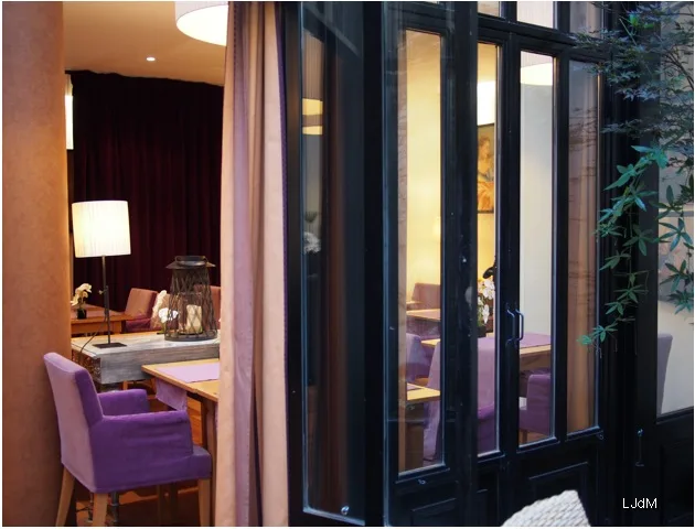 Coin repas d'hôtel ouvrant sur une cour