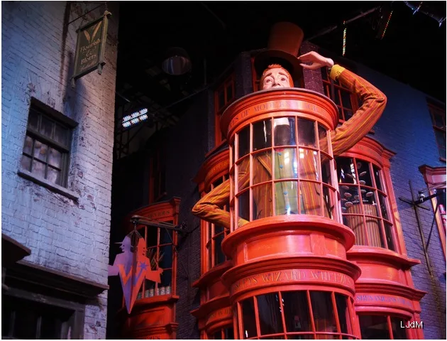Figure de sorcier penchée sur une vitrine rouge des studios Harry Potter