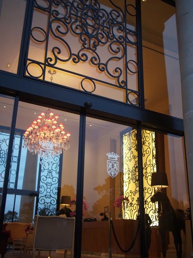 Lustre du hall vu à travers les portes d'entrée de l'hôtel