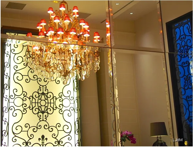 Lustre en cristal rouge à côté d'un écran en fer forgé orné
