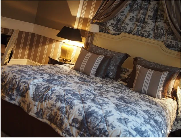 Lit double à motifs et murs rayés dans une chambre de style château