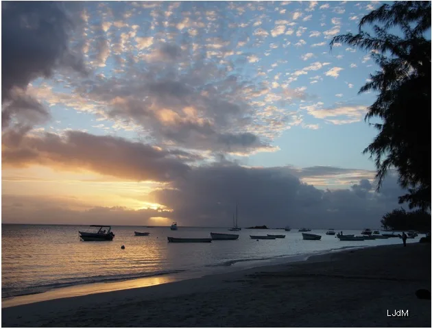 Coucher de soleil sur une plage de l’île Maurice avec des barques