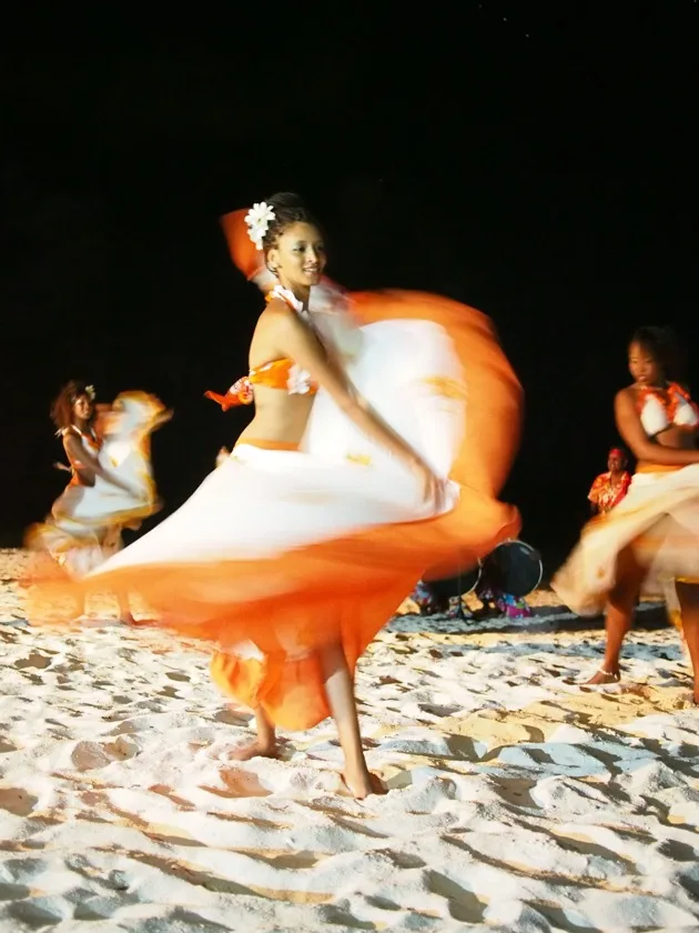 Danseuse mauricienne en costume orange lors d’un spectacle nocturne