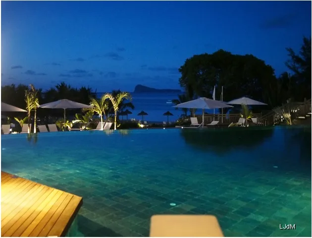 Piscine de l’hôtel face au lagon dans la lumière bleue du soir
