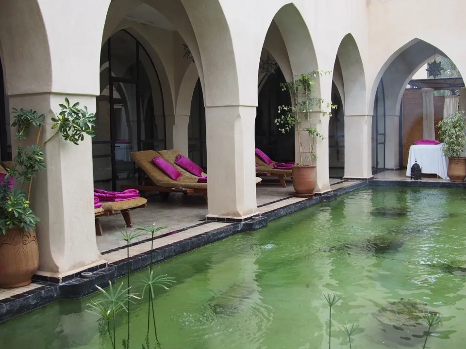 Colonnade voûtée au bord d'une piscine de riad à Marrakech