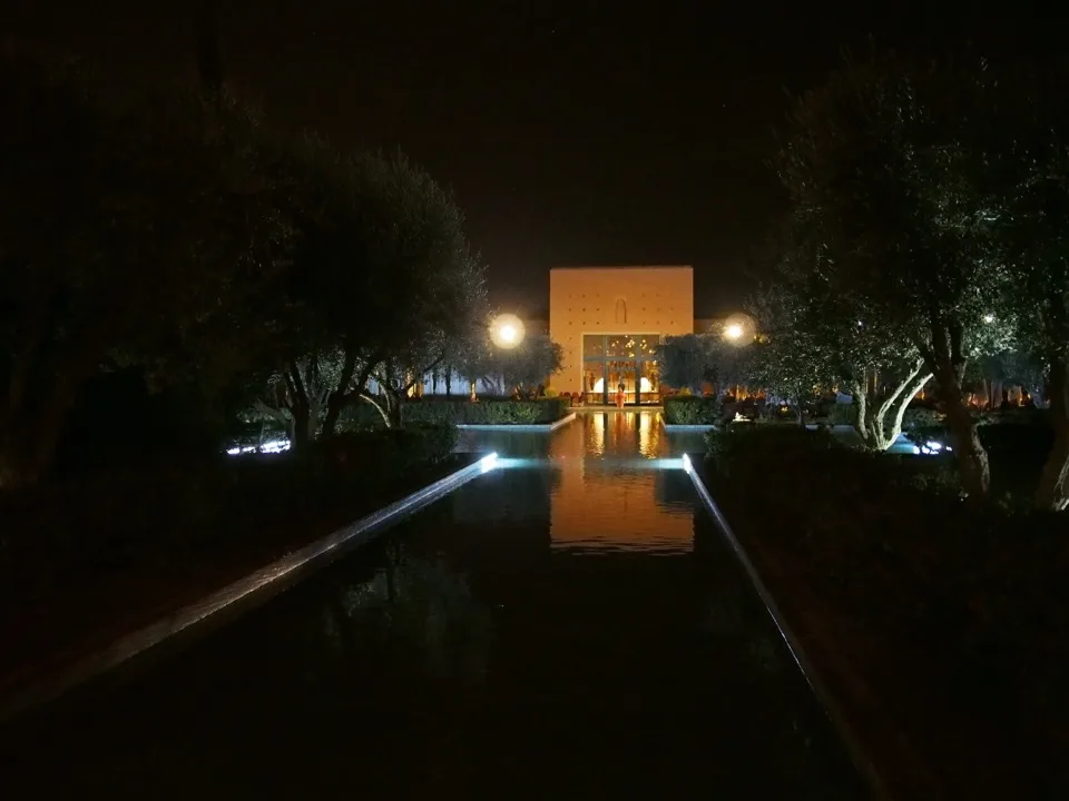 Arches éclairées reflétées dans une piscine la nuit