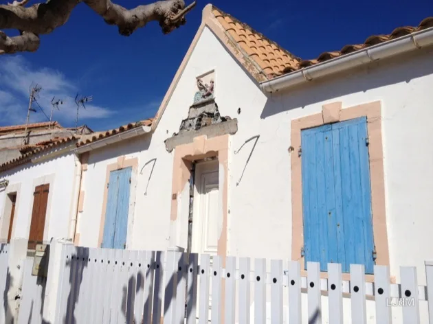 Maison blanche aux volets bleus dans un village côtier français