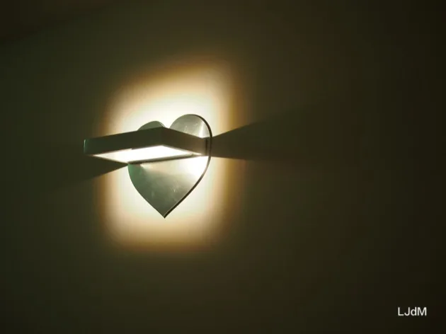 Applique en forme de cœur qui brille dans une chambre d'hôtel