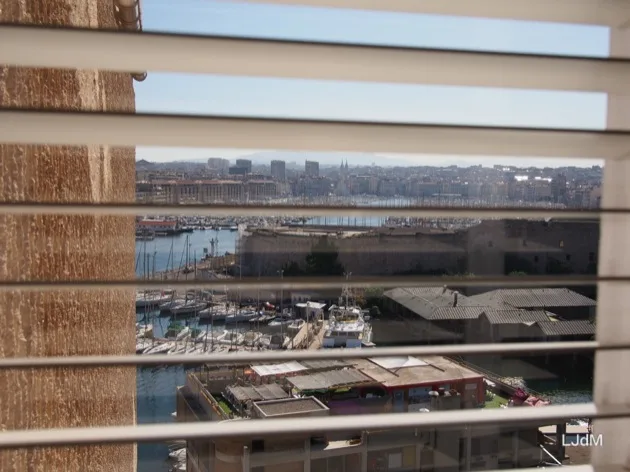 Le Vieux-Port de Marseille vu à travers les stores des hôtels