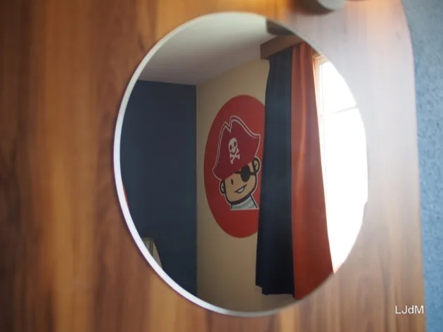 Miroir rond dans une chambre d'hôtel sur le thème des pirates