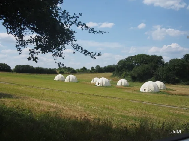 Dômes de glamping blancs dans un pré à Echologia