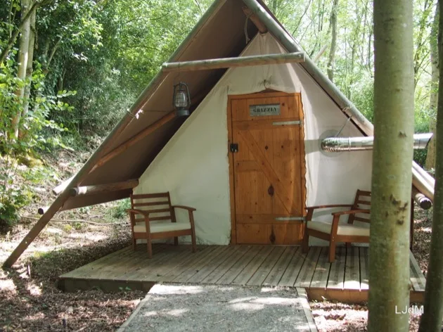 Lodge toilé avec porte en bois au milieu des arbres à Echologia