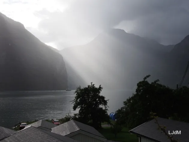 Rayons de soleil traversant les nuages au-dessus d'un fjord norvégien