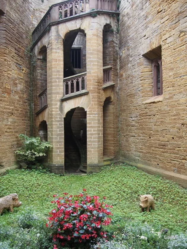 Façade de pierre et parterre fleuri dans la cour d'un château