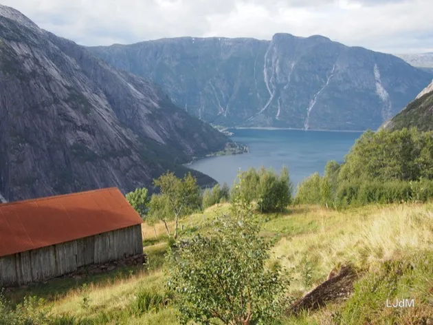 Grange au toit rouge surplombant un fjord norvégien