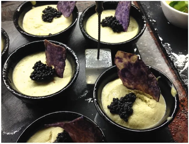Bols de soupe crémeuse garnis de caviar noir et de chips violettes