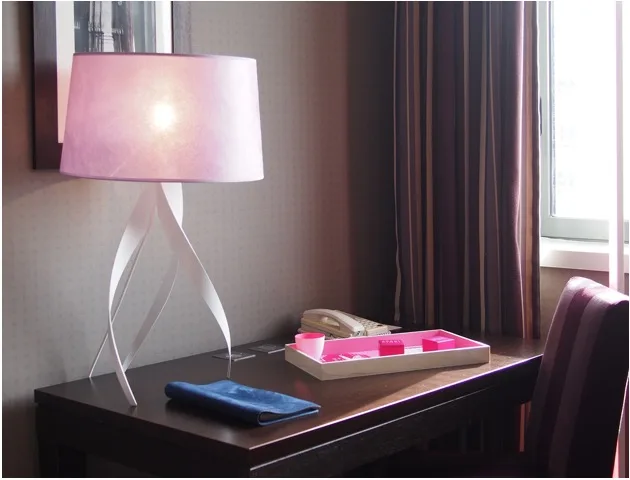 Lampe rose et plateau de bienvenue dans une chambre d'hôtel