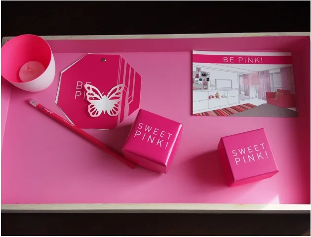 Papeterie rose et cadeaux disposés sur un plateau