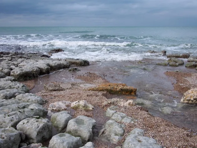 Bassins rocheux et vagues sous les falaises d'Étretat