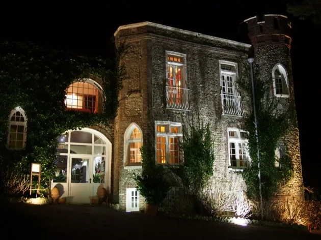 Hôtel couvert de lierre illuminé la nuit à Étretat
