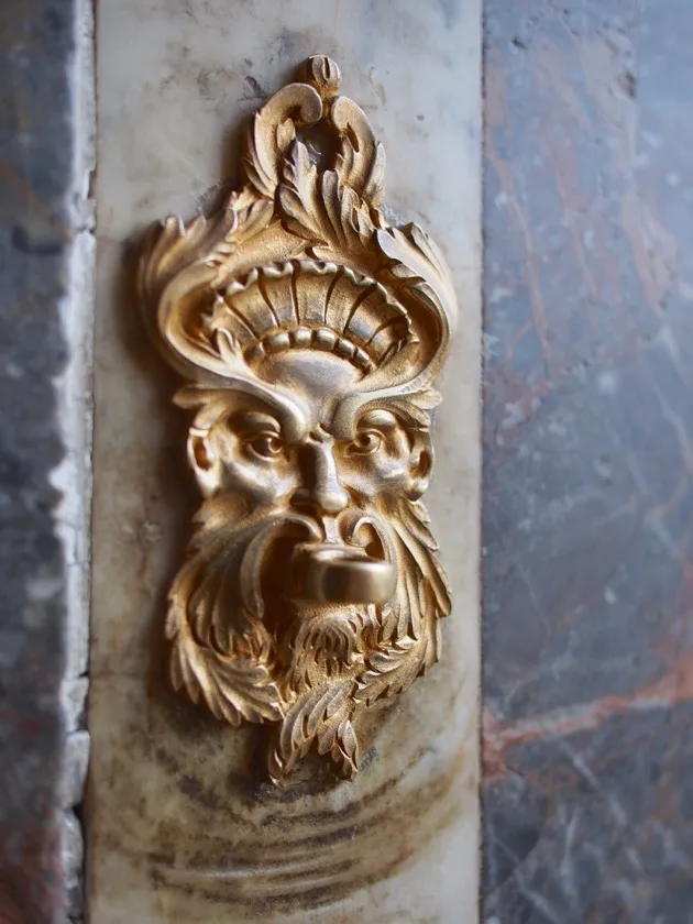 Ornement tête de lion doré sur un mur de marbre