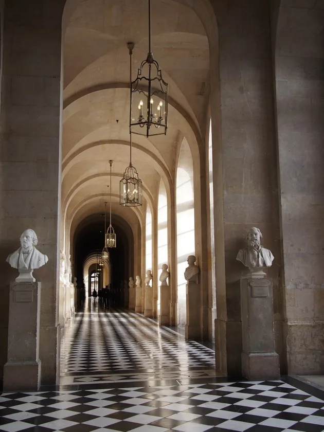 Long couloir voûté avec sol en damier à Versailles