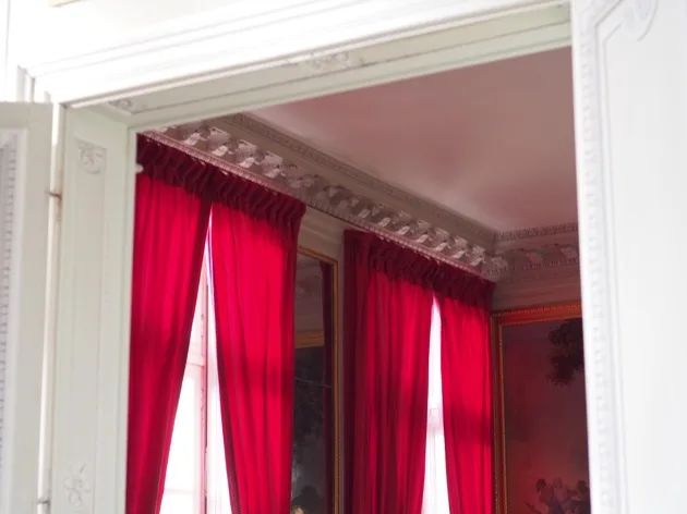 Rideaux rouges à l'intérieur du Petit Trianon