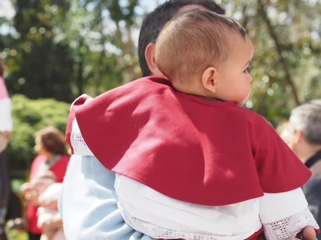 Un membre de la famille regarde une procession de la Semaine Sainte par derrière
