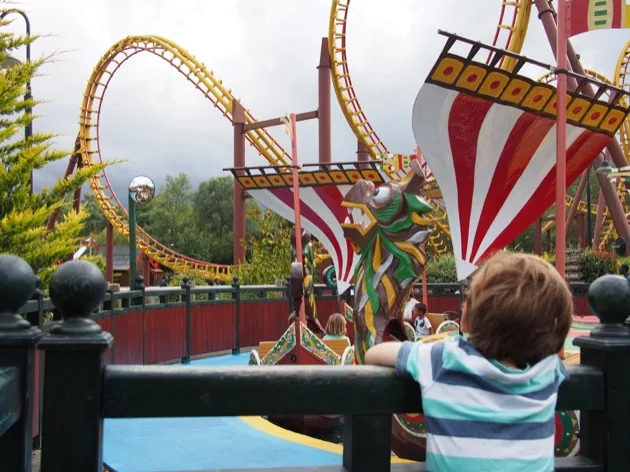 Famille regardant des montagnes russes sur le thème des Vikings au Parc Astérix
