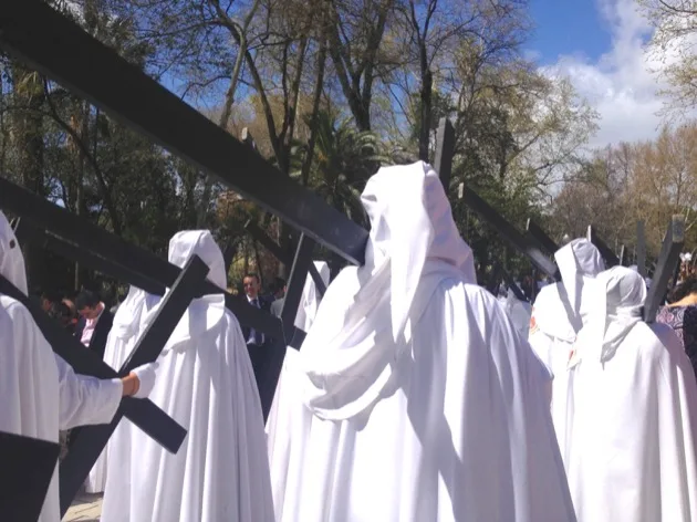 Pénitents portant une croix pendant la Semaine Sainte à Séville