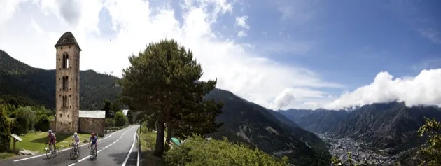 Cyclistes passant devant une église romane en Andorre