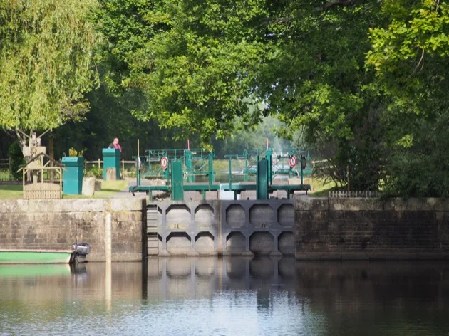 Portes d'écluse reflétées dans l'eau calme du canal