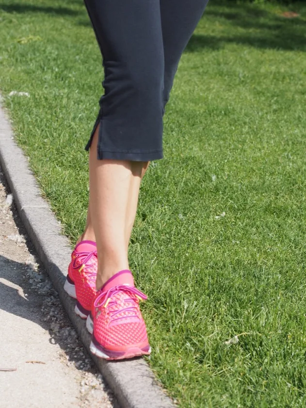 Coureur en chaussures rose vif sur un chemin pavé
