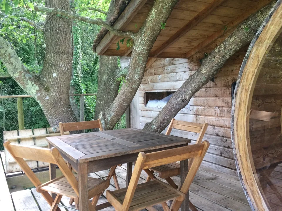 Terrasse couverte en bois d'une cabane dans les arbres