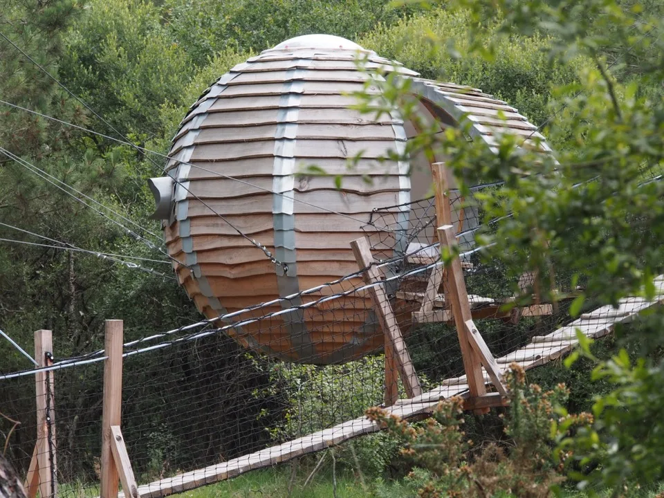 Pod rond en bois atteint par un pont de corde