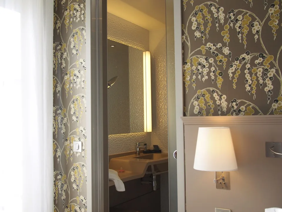 Salle de bain d'une chambre avec papier peint à motifs