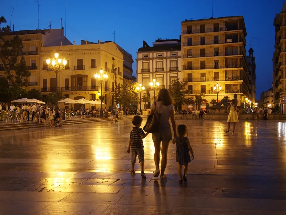 Famille de dos sur une place éclairée du centre de Valence