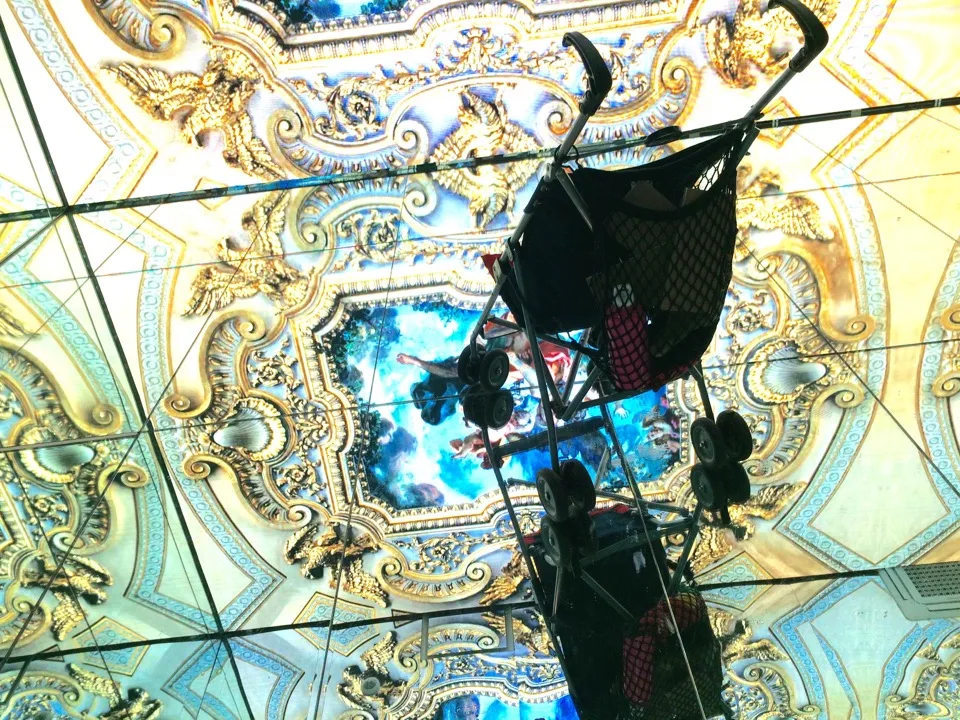 Installation lumineuse suspendue sous un plafond peint orné
