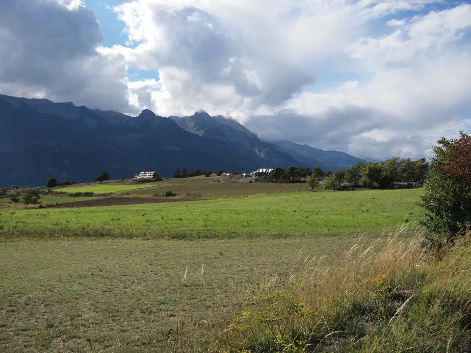 Prairies et montagnes sous des nuages spectaculaires près de Guillestre