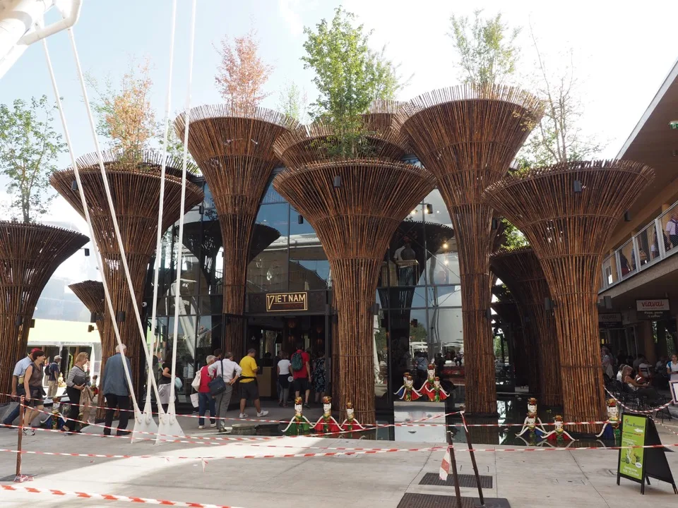 Structures en bois ressemblant à des arbres le long d'une passerelle pour l'Expo
