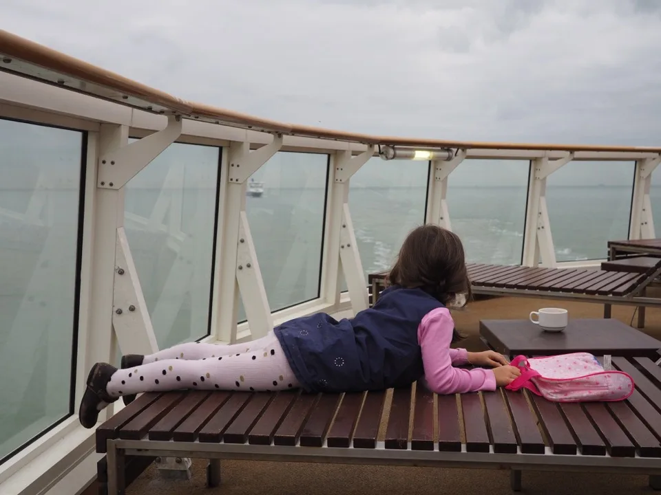 Famille de dos se reposant sur le pont d'un ferry